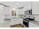 Bright kitchen features white cabinets, stainless appliances, and granite countertops at 6713 Brookhollow Dr, Raleigh, NC 27615