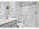 Bright bathroom featuring a glass shower, gray vanity, and modern fixtures at 701 Prince Dr, Holly Springs, NC 27540