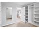 Walk-in closet offering ample storage space with custom shelving and a view of the bathroom at 701 Prince Dr, Holly Springs, NC 27540