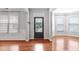 Bright foyer featuring hardwood floors, natural light, and a modern front door at 701 Prince Dr, Holly Springs, NC 27540