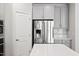 Modern kitchen features stainless steel refrigerator, stylish gray cabinets, and island with white countertop at 701 Prince Dr, Holly Springs, NC 27540