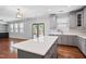 Open kitchen design with island, gray cabinetry, and easy access to outdoor deck at 701 Prince Dr, Holly Springs, NC 27540
