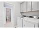 Laundry room with washer, dryer, and gray cabinets at 701 Prince Dr, Holly Springs, NC 27540