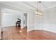 Bright open-concept living room featuring hardwood floors and a chandelier at 701 Prince Dr, Holly Springs, NC 27540