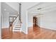 Open-concept living room with hardwood floors and an elegant staircase at 701 Prince Dr, Holly Springs, NC 27540