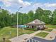 Community pool with surrounding trees, lounge chairs, and a cabana with shade at 701 Prince Dr, Holly Springs, NC 27540