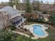 Aerial view of a home with a pool, screened porch, stone patio, and landscaped backyard at 705 Glen Eden Dr, Raleigh, NC 27612