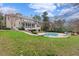 Expansive backyard featuring a stone-lined pool, patio, and lush greenery, perfect for outdoor entertaining and relaxation at 705 Glen Eden Dr, Raleigh, NC 27612