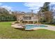 Large backyard featuring a pool, stone accents, screened porch, and lush landscaping at 705 Glen Eden Dr, Raleigh, NC 27612