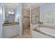 Luxurious bathroom with a glass-enclosed shower, soaking tub, and elegant vanity with granite countertops at 705 Glen Eden Dr, Raleigh, NC 27612