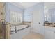 Bathroom with a soaking tub under a window and a glass-enclosed shower and granite countertop vanity at 705 Glen Eden Dr, Raleigh, NC 27612