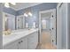 Bright bathroom with double sinks, white cabinets, and a large mirror reflecting the serene, light-filled space at 705 Glen Eden Dr, Raleigh, NC 27612