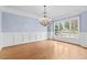 Formal dining room with large windows, hardwood floors, elegant chandelier and classic wainscoting at 705 Glen Eden Dr, Raleigh, NC 27612