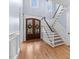 Inviting entryway with hardwood floors, staircase, and a stylish front door with decorative wreaths at 705 Glen Eden Dr, Raleigh, NC 27612