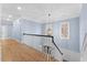 Hallway featuring wooden floors, light blue walls, and white banister, offering a view to the outside at 705 Glen Eden Dr, Raleigh, NC 27612