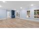 Living room with wood floors, and blue built-in shelving, with large windows offering bright light at 705 Glen Eden Dr, Raleigh, NC 27612