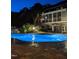 This outdoor pool at night features ambient lighting and access to the home's screened porch at 705 Glen Eden Dr, Raleigh, NC 27612
