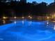 Backyard pool at night has ambient lighting and stonework features at 705 Glen Eden Dr, Raleigh, NC 27612