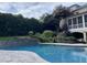 Backyard pool features stone accents and steps, lush landscaping, and easy access to a screened porch at 705 Glen Eden Dr, Raleigh, NC 27612