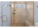 Bathroom shower featuring sleek glass doors, tiled walls, pebble flooring, and a built-in shower bench at 705 Glen Eden Dr, Raleigh, NC 27612