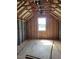 An attic room under construction with exposed wood framing, a plywood subfloor, and a single window providing natural light at 72 Cultivator Ct, Angier, NC 27501