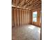 Unfinished room highlighting wood framing, exposed beams, and natural light from window at 72 Cultivator Ct, Angier, NC 27501
