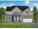 Charming two-story home featuring stone accents, a welcoming front porch, and a well-manicured lawn at 72 Cultivator Ct, Angier, NC 27501