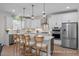 Bright kitchen boasts white cabinets, stainless steel appliances, a center island and stylish pendant lights at 72 Cultivator Ct, Angier, NC 27501