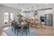 Open kitchen with dining table, bar seating, stainless appliances, and backyard access at 72 Cultivator Ct, Angier, NC 27501