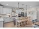 Modern kitchen featuring white cabinets, stainless steel appliances, an island with bar seating, and hardwood floors at 72 Cultivator Ct, Angier, NC 27501