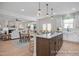 Open-concept kitchen with an island, seating, and seamlessly connected to the living and dining areas at 72 Cultivator Ct, Angier, NC 27501