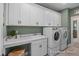 Well-equipped laundry room with white cabinets, modern appliances, and a convenient countertop at 72 Cultivator Ct, Angier, NC 27501