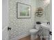 Stylish powder room with patterned wallpaper, pedestal sink, and decorative gold shelving at 72 Cultivator Ct, Angier, NC 27501