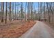 Long ranch style home with black shutters sits among mature trees along a private drive at 7214 Southern Trl, Chapel Hill, NC 27516