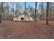 Side view of the ranch home, displaying the backyard, trees, and access to a back door at 7214 Southern Trl, Chapel Hill, NC 27516