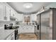 Well-lit kitchen features white cabinets, stainless steel appliances, and a window view at 7214 Southern Trl, Chapel Hill, NC 27516