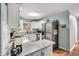 A modern white kitchen with stainless steel appliances and marble countertops at 7214 Southern Trl, Chapel Hill, NC 27516