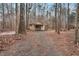 Outbuilding with gravel front yard, surrounded by mature trees at 7214 Southern Trl, Chapel Hill, NC 27516