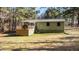 View of the rear of the home with a wooden deck and green grass at 749 Fred Royster Rd, Henderson, NC 27537
