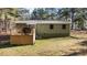 Back view of the property with a wooden back porch and lush grass at 749 Fred Royster Rd, Henderson, NC 27537