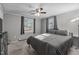 Sunlit bedroom featuring neutral decor, two windows, and a cozy carpeted floor at 749 Fred Royster Rd, Henderson, NC 27537