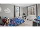 Neutrally decorated bedroom with gray walls, carpet, two windows and a bed with toy-themed covers at 749 Fred Royster Rd, Henderson, NC 27537