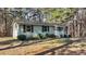 Quaint single-story house with a metal roof, framed by lush trees and manicured bushes at 749 Fred Royster Rd, Henderson, NC 27537