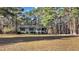 Inviting single-story home featuring a well-kept lawn and surrounded by lush, mature trees at 749 Fred Royster Rd, Henderson, NC 27537