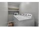 Functional laundry room with a white washer and dryer, shelving and vinyl floor at 749 Fred Royster Rd, Henderson, NC 27537