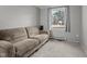Comfortable living room featuring neutral gray walls, carpet, and a tan couch under a window at 749 Fred Royster Rd, Henderson, NC 27537