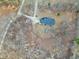 An aerial view of a well-maintained home with a dark roof surrounded by a wooded landscape and a long driveway at 8724 Ten Ten Rd, Raleigh, NC 27603