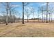 View of the sprawling backyard, accented with bare trees and expansive open space under a blue sky at 8724 Ten Ten Rd, Raleigh, NC 27603