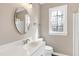 Bathroom with a white vanity, mirror and natural light from the window at 8724 Ten Ten Rd, Raleigh, NC 27603