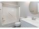 Functional bathroom featuring a tub-shower combo with a round mirror and a white single sink vanity at 8724 Ten Ten Rd, Raleigh, NC 27603